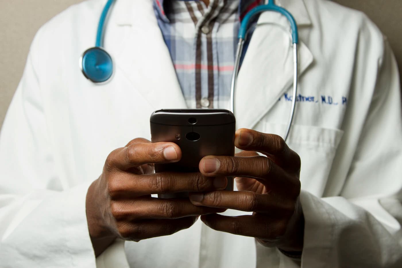 Médico usando o celular durante atendimento